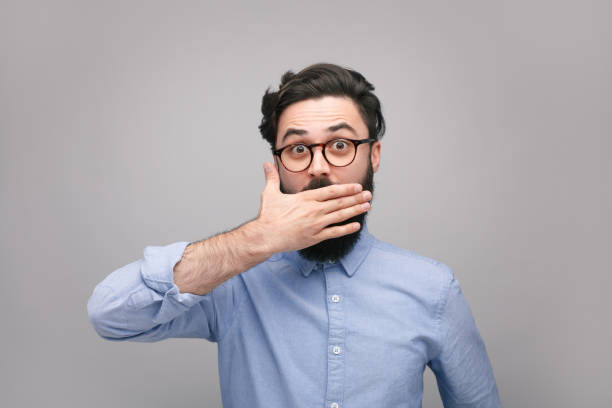 istock Confused man covering mouth in silence 1094980668