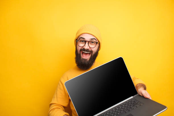 istock Smiling hipster in glasses posing with laptop 1094980690