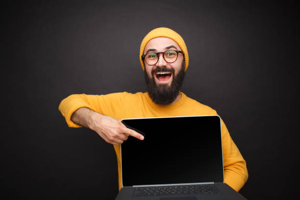 istock Smiling man pointing at laptop 1094980716