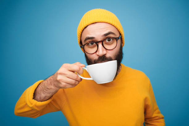 �コーヒーを飲みながらスタイリッシュな男 - elegance yellow glasses eyewear ストックフォトと画像