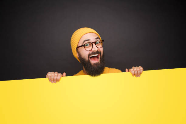 istock Laughing man behind yellow blank paper 1094980728