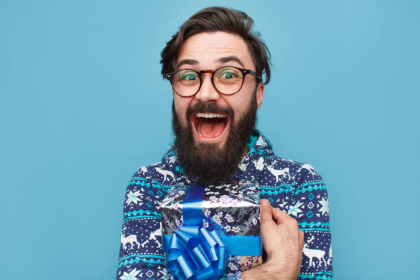 istock Young bearded man with wrapped blue gift 1094980734