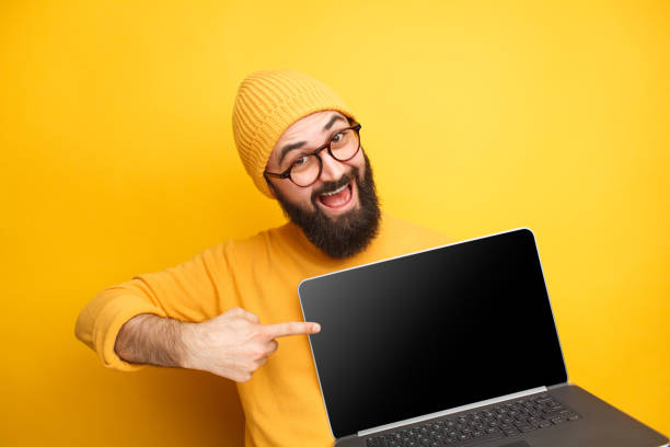 istock Cheerful man pointing at laptop 1094980754