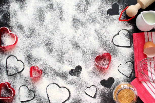 istock Baking background with flour, rolling pin, eggs, milk, sugar cane and heart shape on dark background. 1094982960