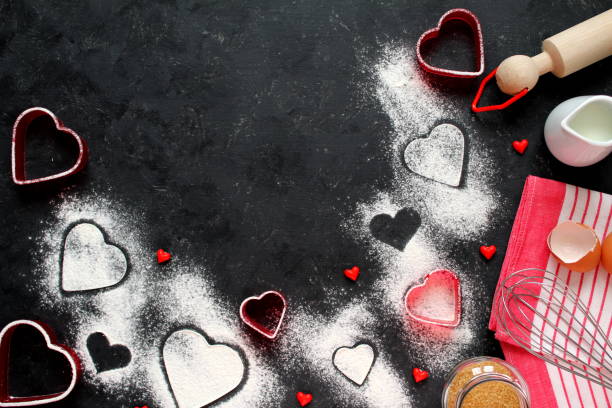 istock Baking background with flour, rolling pin, eggs, milk, sugar cane and heart shape on dark background. 1094983096