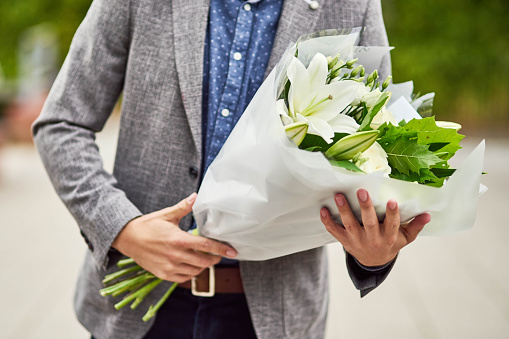 Cropped shot of a man holding a bouquet of flowers