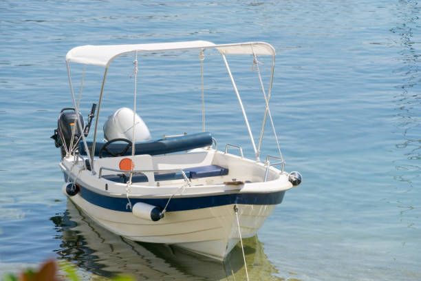 istock Small white blue motorized boat anchored on the shore. 1094987226