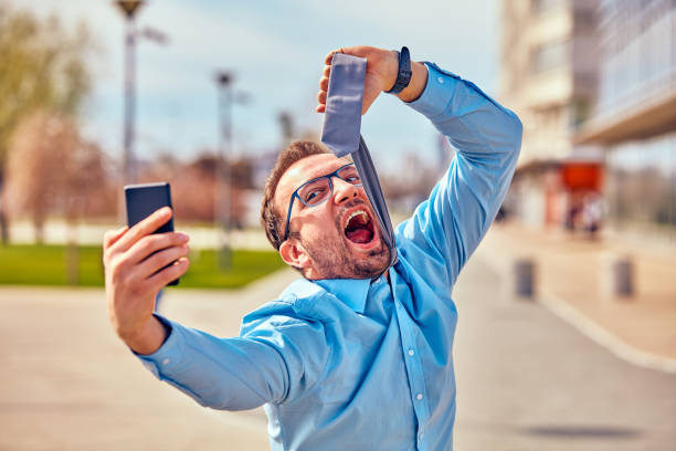 istock Funny businessman getting angry while using smartphone outdoors. 1094989628