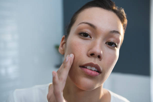 istock Woman applying lotion on her face in bathroom 1094989930