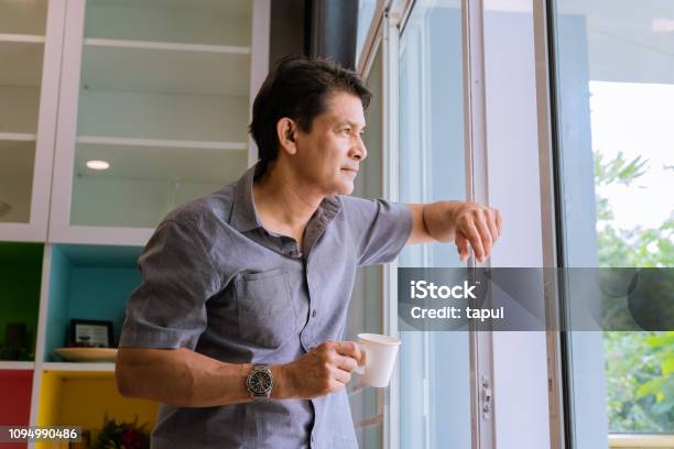 The Man Looks Outside Standing At The Open Window Of His Apartment Staying  At Home During The Epidemic And Quarantine Stock Photo - Download Image Now  - iStock