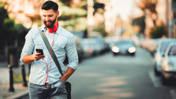 istock Smiling man texting on the street 1094993504