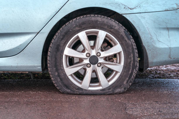 Deflated tyre damage to blue car wheel Deflated tyre damage to blue car wheel flat tire stock pictures, royalty-free photos & images