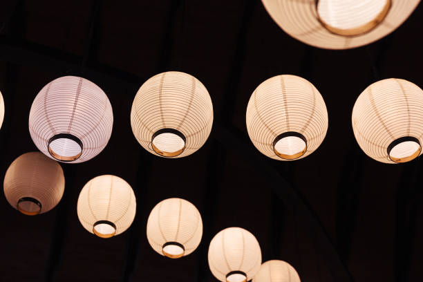 istock Lighted white paper lamps on ceiling in black background. 1095005642