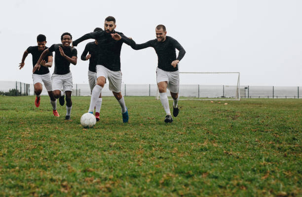 istock Group of men playing soccer on the field 1095015482