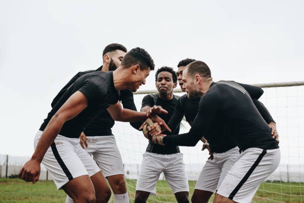 istock Soccer players joining hands standing in a huddle 1095015664