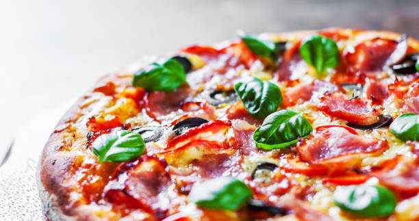 istock Pizza with Mozzarella cheese, ham, pepper, olive, meat, Tomato sauce, Spices and Fresh Basil. Italian pizza on wooden background 1095017982
