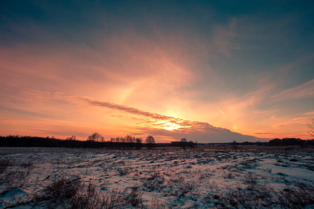 Winter snowy scenery. Snow covered field at sunset