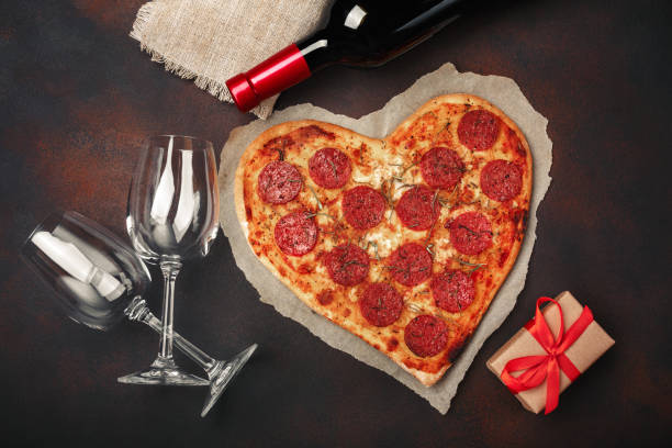 herzförmige pizza mit mozzarella, sausagered, weinflasche, zwei weinglas geschenkkarton auf rostigen hintergrund - food and drink holidays and celebrations people valentines day stock-fotos und bilder