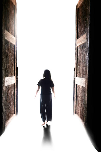 istock woman walking into the light through open big door, to go to nirvana, every cloud has a silver lining, There’s a light at the end of the tunnel 1095026752