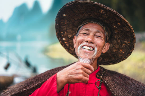 Chinese senior man looking confident standing outside of small village food store. Chinese Real People Portrait. Chengyang, Sanjiang, Guizhou, China. Unretouched Hand written copyright free background.