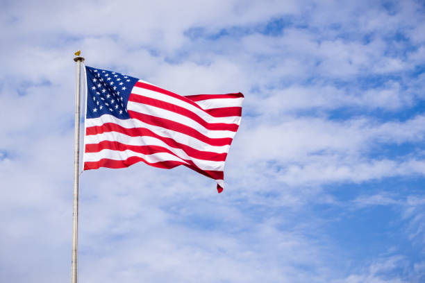 istock The USA flag on a cloudy sky background 1095027798