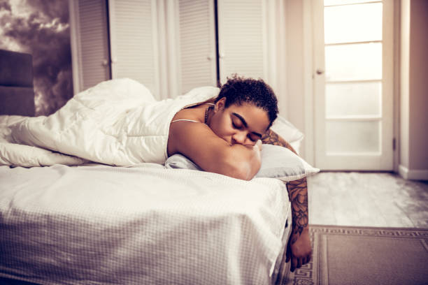istock Dark-haired woman with thick brows sleeping in white bad 1095030152