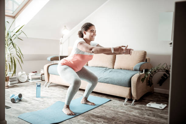 istock Beaming dark-haired African American woman actively squatting 1095030350