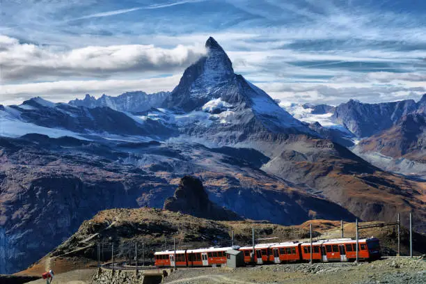 Zermatt Switzerland. Famous electric red tourist train coming down  in Zermatt Valais region Switzerland Europe.