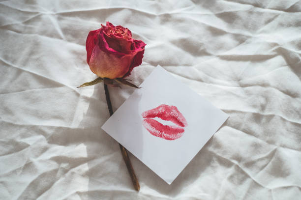 istock a note with a kiss and dried rose on a white bed. Valentines day concept. 1095032466