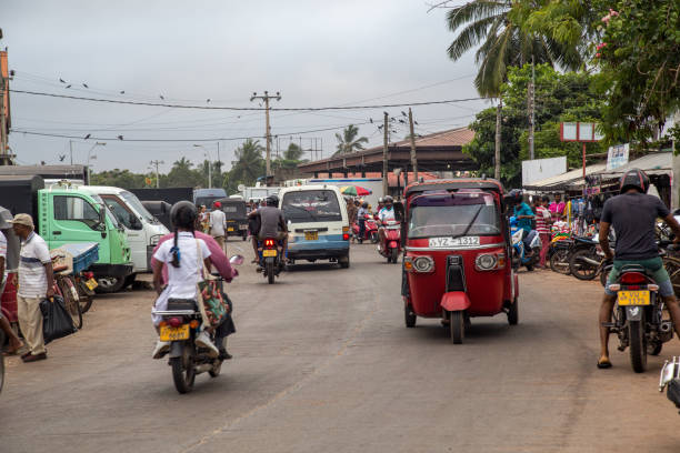 Busy road in Negombo, Sri Lanka Negombo, Sri Lanka - July 25, 2018: A busy road with motorcycles, cars and tuk tuks close at the fish market taxi sri lanka stock pictures, royalty-free photos & images
