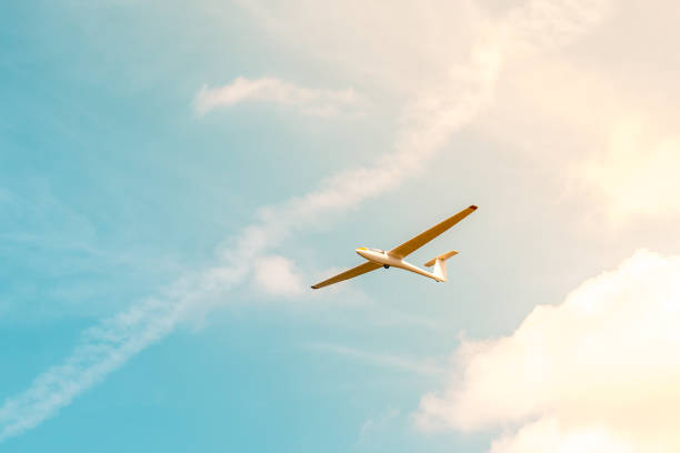 istock Glider flying against the blue sky with clouds and sunlight 1095043248