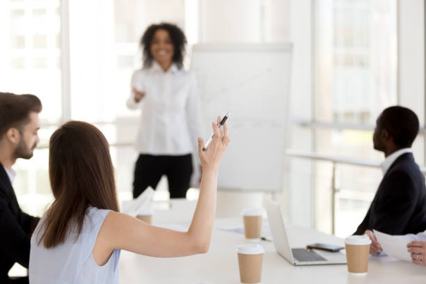 istock Rear view at woman raising hand asking question concept 1095046952