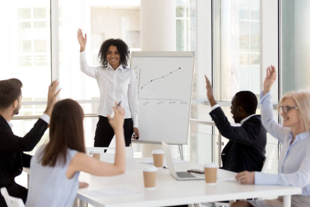 istock Smiling african-american coach raising hand with team voting at training 1095046972