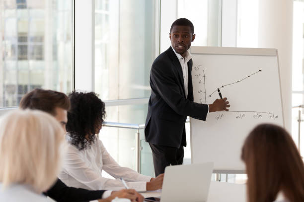 istock Serious african american mentor giving presentation explaining sales growth graph 1095046984