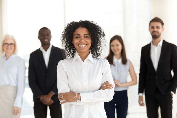 istock Smiling african employee standing with diverse team in office, portrait 1095047192