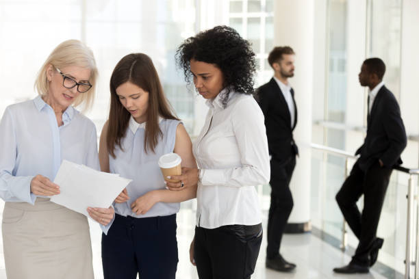 istock Mature team leader and young employees discussing paperwork in office 1095047204
