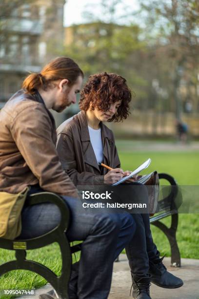 Postgrad Students Taking Notes Studying In The Park Stock Photo - Download Image Now