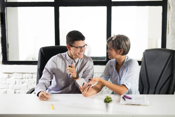 istock Young happy colleagues sitting together in the office 1095051696