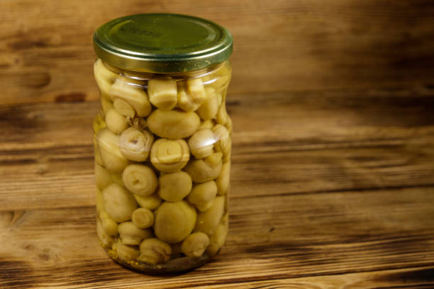 istock Delicious marinated mushrooms in glass jar on wooden table 1095051990