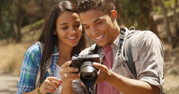 istock Happy young backpacking couple with camera looking at pictures 1095055512