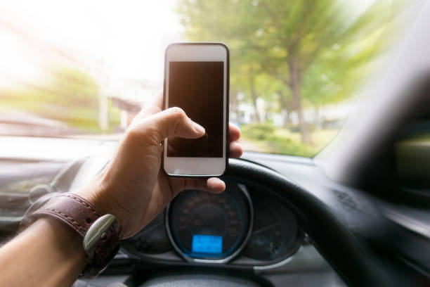 istock Close up man hand using smart phone while  he is driving the car 1095058438