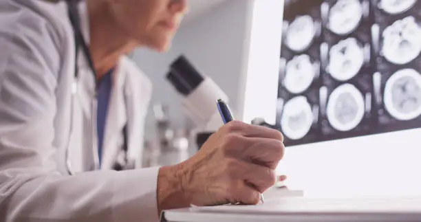 Intelligent female radiologist analyzing with microscope