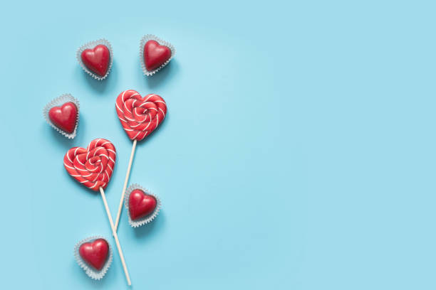 tarjeta de san valentín. piruletas de caramelo como centro en azul. concepto divertido. - valentine candy fotografías e imágenes de stock