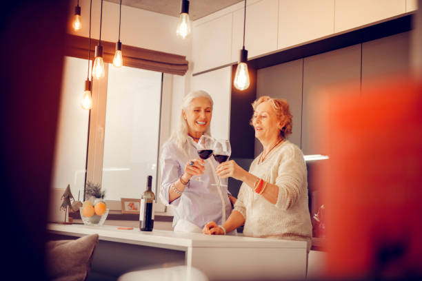 Nice aged women standing together in the kitchen