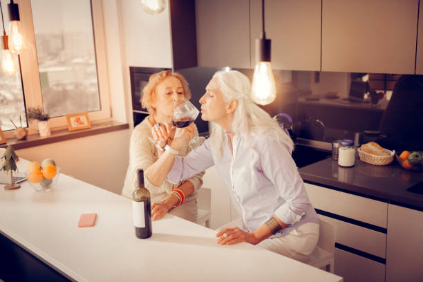 istock Happy senior women drinking red wine together 1095066604