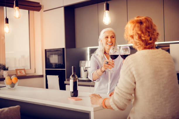 istock Joyful senior sisters clinking with wine glasses 1095066640