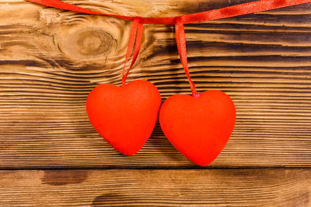 dos corazones rojos sobre un fondo de madera. vista superior - 5519 fotografías e imágenes de stock