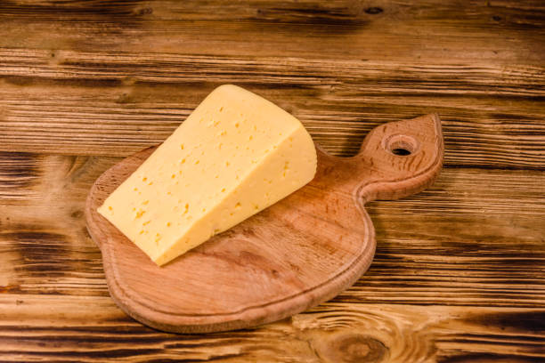 placa com um pedaço de queijo de corte na mesa de madeira - block portion part of french culture - fotografias e filmes do acervo