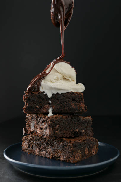 verter el chocolate caliente en brownies - chocolate topping fotografías e imágenes de stock