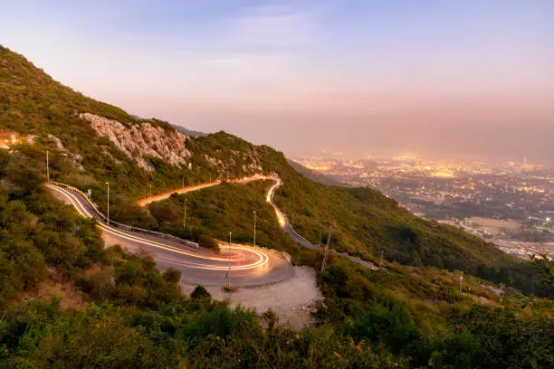 Car tail lights winding down the road on margalla hills in Islamabad, Pakistan.